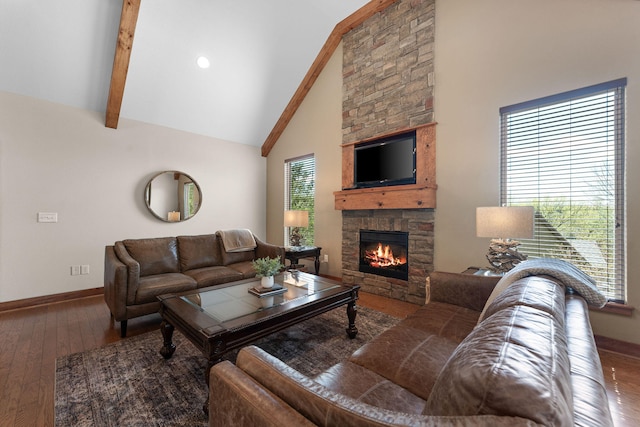 living room featuring high vaulted ceiling, hardwood / wood-style flooring, beamed ceiling, and a stone fireplace