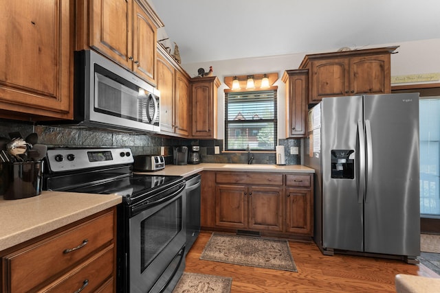 kitchen with dark hardwood / wood-style floors, sink, stainless steel appliances, and backsplash