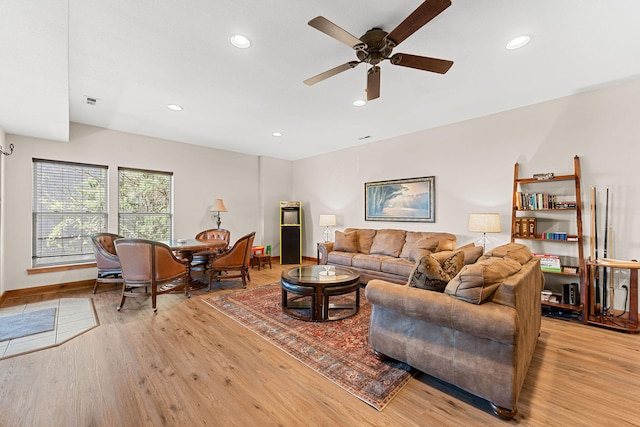 living room featuring ceiling fan and light hardwood / wood-style flooring