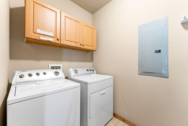 laundry area featuring electric panel, independent washer and dryer, light tile patterned floors, and cabinets