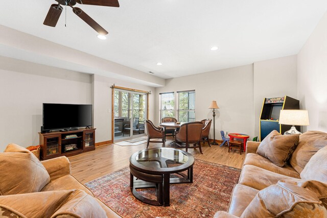 living room featuring light hardwood / wood-style floors and ceiling fan