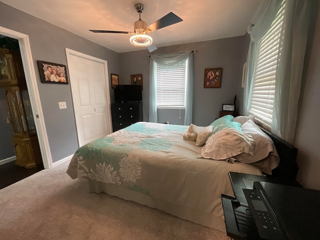 carpeted bedroom featuring multiple windows, a closet, and ceiling fan