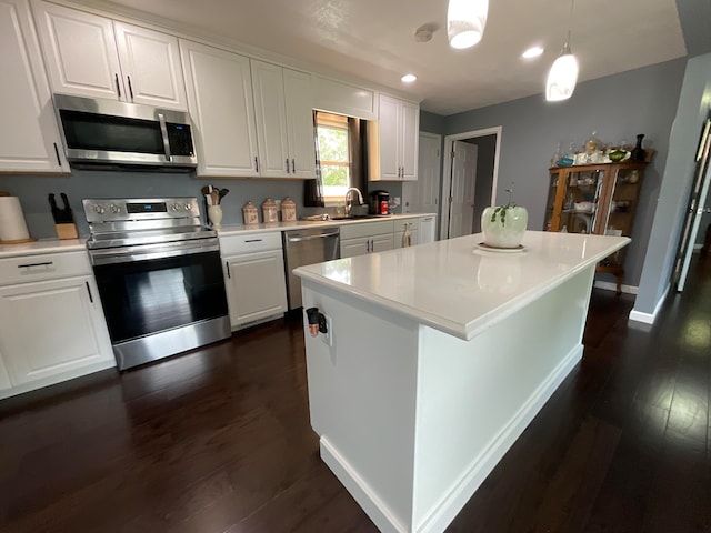 kitchen featuring pendant lighting, white cabinetry, and appliances with stainless steel finishes