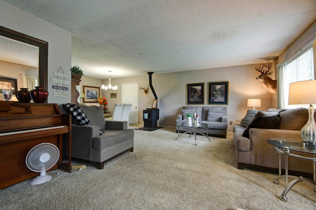 carpeted living room featuring a wood stove, a chandelier, and a textured ceiling