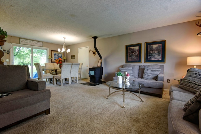 carpeted living room with a wood stove, a chandelier, and a textured ceiling