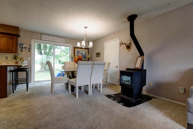 carpeted dining space featuring a wood stove, a notable chandelier, and a textured ceiling