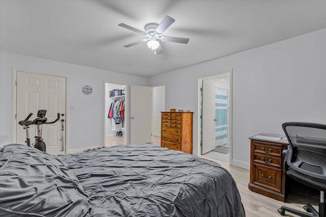 bedroom with ceiling fan, a closet, light hardwood / wood-style floors, ensuite bath, and a walk in closet