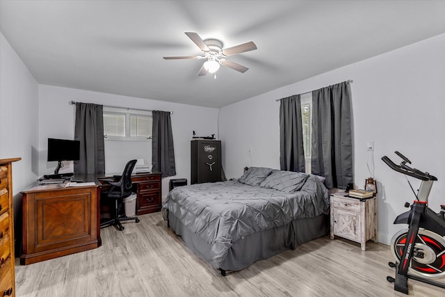 bedroom featuring ceiling fan, light hardwood / wood-style flooring, and multiple windows