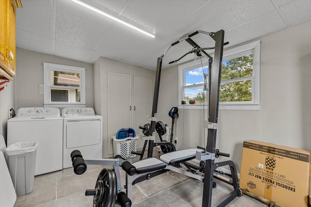 exercise room featuring washing machine and dryer and light tile patterned floors