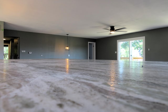 unfurnished living room featuring a ceiling fan