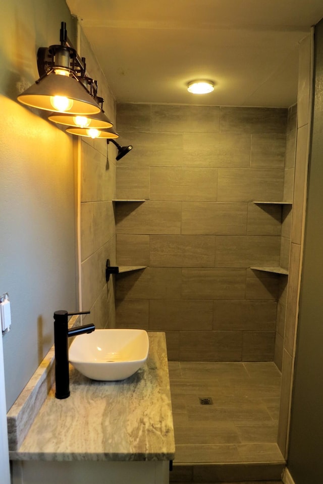 bathroom featuring a tile shower and vanity