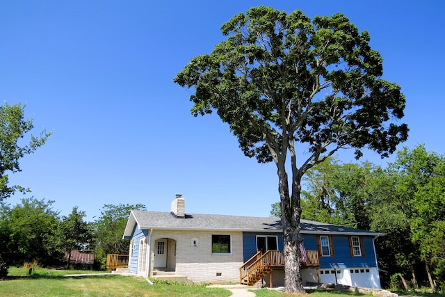 ranch-style house featuring a garage, a front yard, crawl space, and a chimney