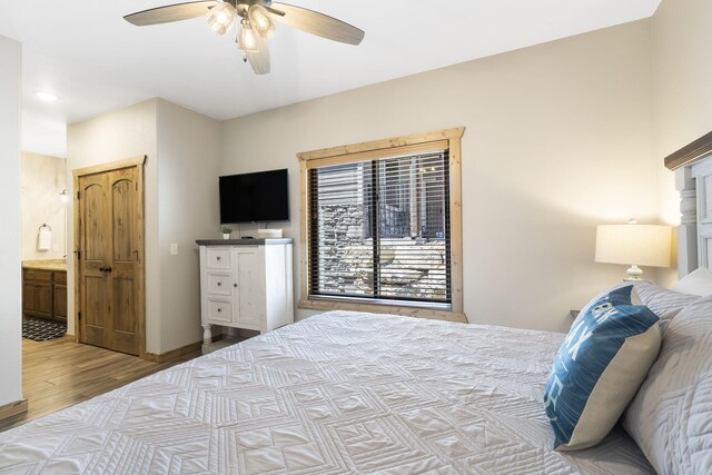 bedroom featuring light wood-type flooring, ceiling fan, and ensuite bathroom