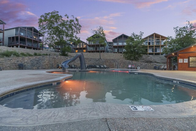 pool at dusk with a water slide