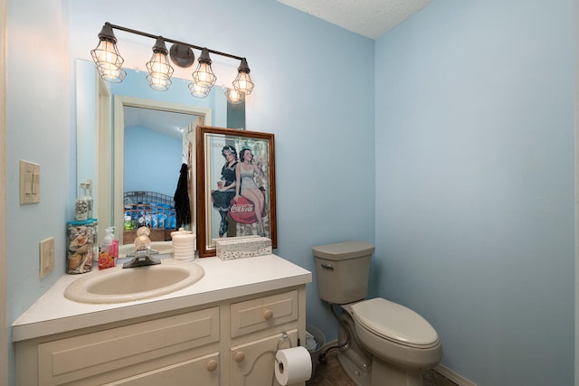 bathroom featuring vanity, toilet, and a textured ceiling