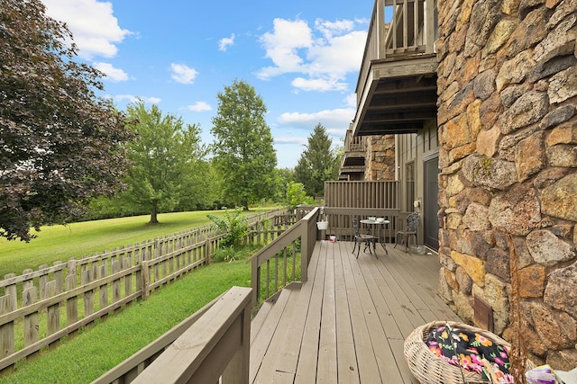 wooden terrace with a yard and fence