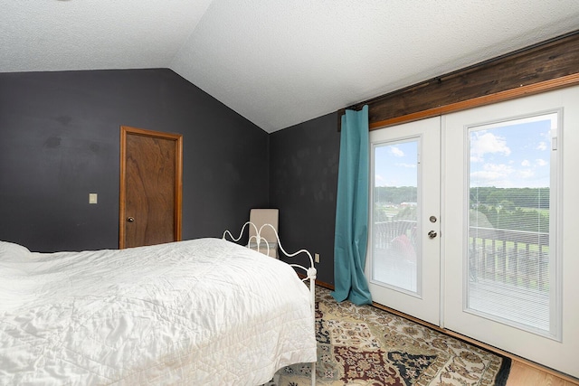 bedroom with a textured ceiling, french doors, lofted ceiling, access to outside, and carpet flooring