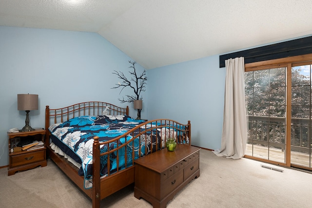 bedroom with light carpet, multiple windows, vaulted ceiling, and a textured ceiling