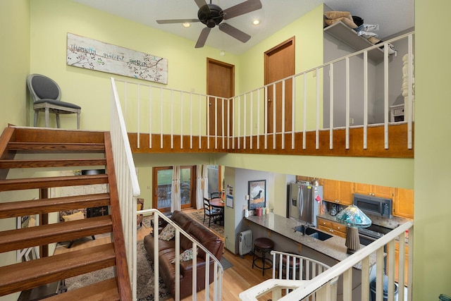 staircase featuring wood finished floors, recessed lighting, and ceiling fan