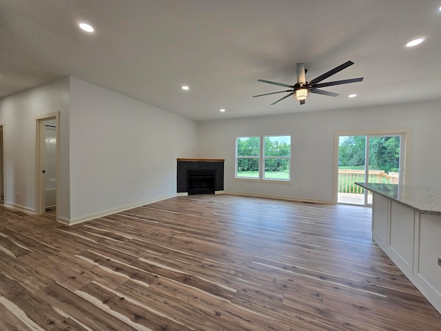 unfurnished living room featuring ceiling fan and dark hardwood / wood-style floors