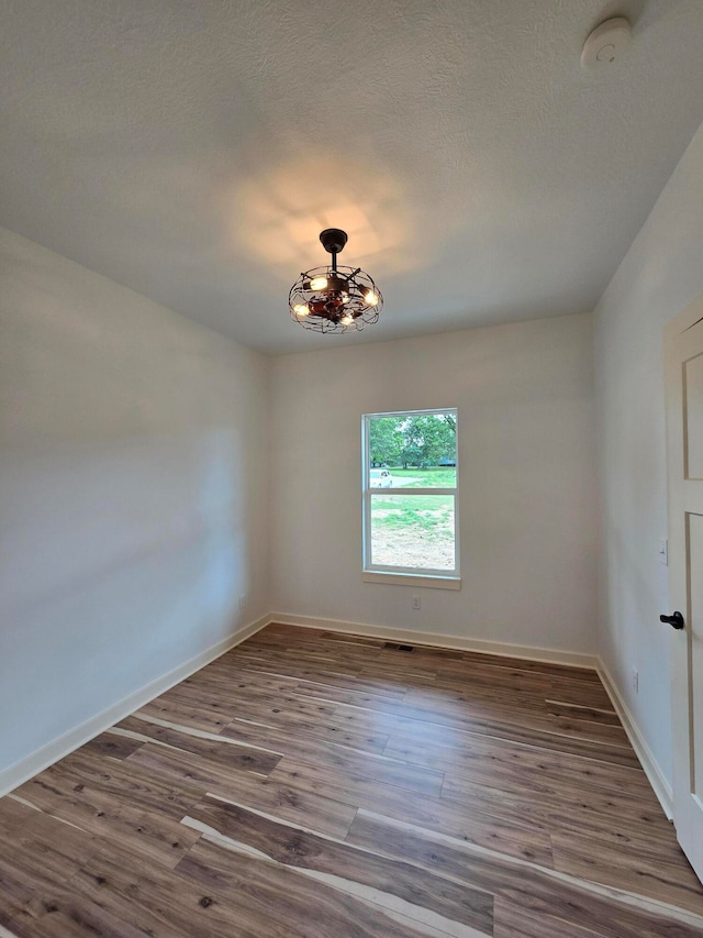 empty room featuring hardwood / wood-style flooring and a textured ceiling