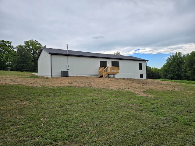 rear view of house with a yard and central AC unit