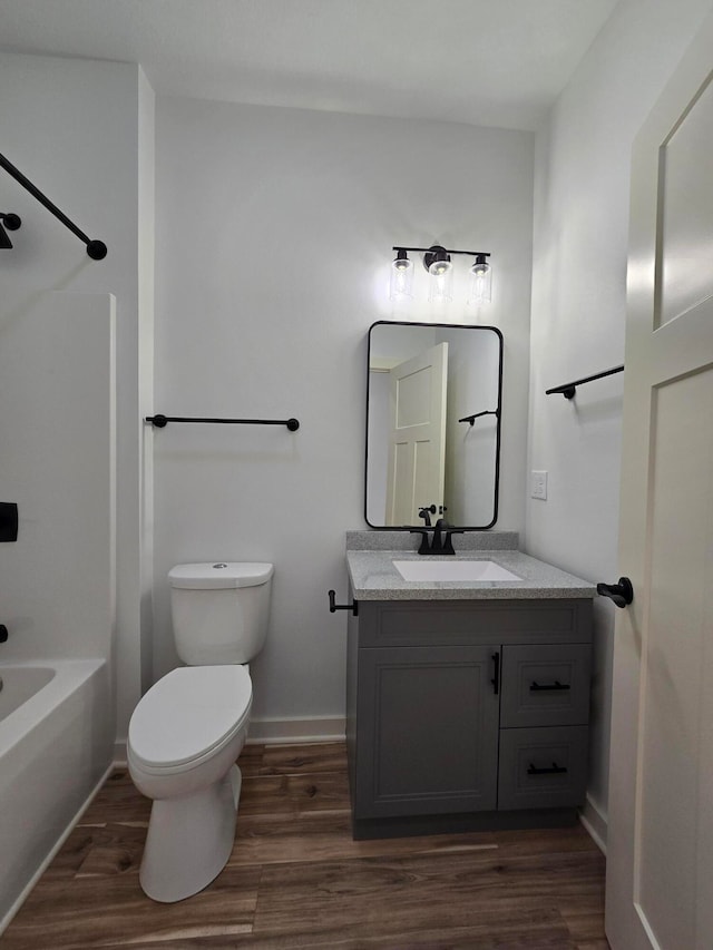 full bathroom featuring shower / bathing tub combination, hardwood / wood-style flooring, vanity, and toilet