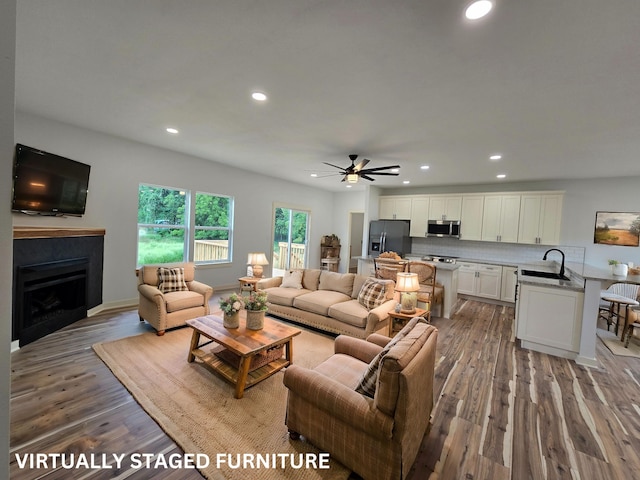 living room with ceiling fan, sink, and wood-type flooring