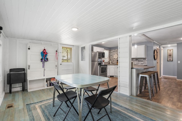 dining space with dark wood-type flooring and wooden ceiling