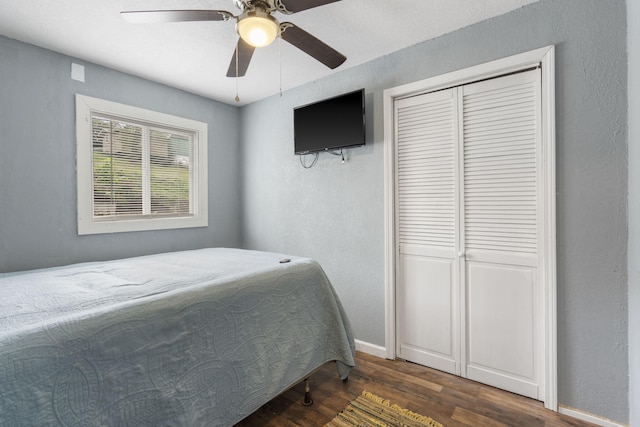 bedroom featuring ceiling fan, dark hardwood / wood-style flooring, and a closet