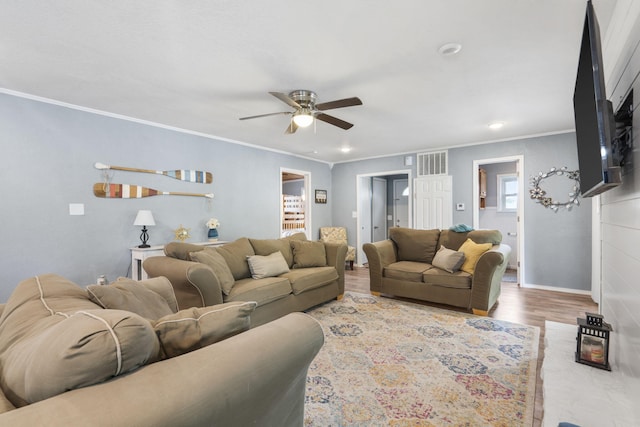 living room featuring hardwood / wood-style flooring, crown molding, and ceiling fan