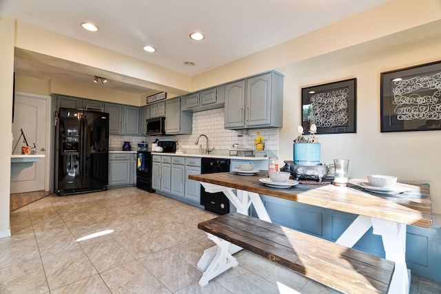 kitchen featuring gray cabinets, backsplash, sink, and black appliances