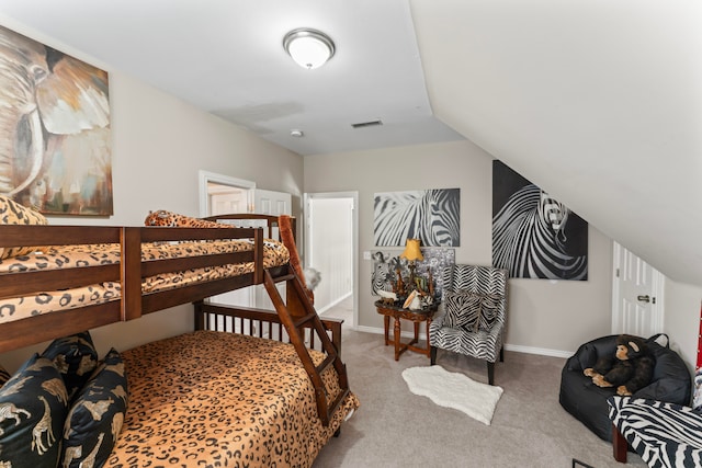 bedroom featuring light carpet and vaulted ceiling