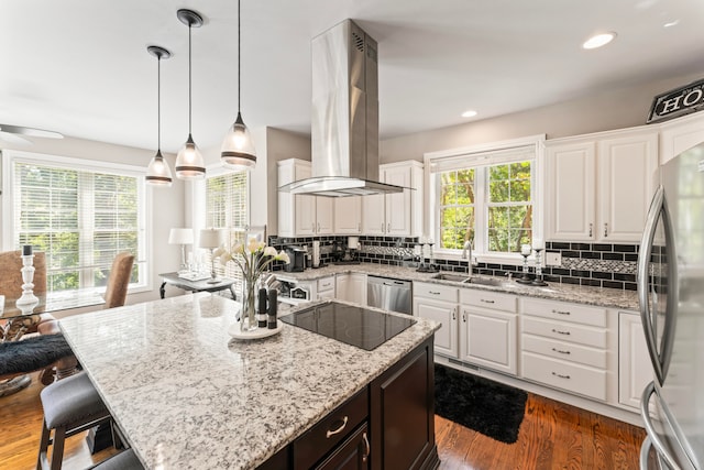 kitchen with wall chimney exhaust hood, dark wood-type flooring, sink, white cabinetry, and appliances with stainless steel finishes