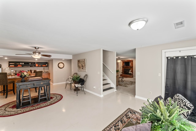 living room featuring ceiling fan, bar area, and concrete floors