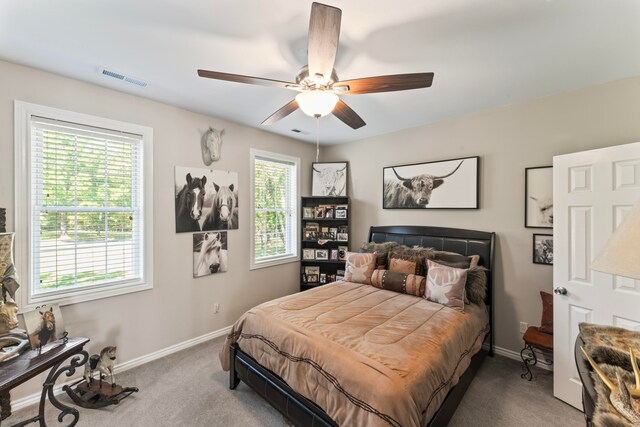 bedroom with multiple windows, ceiling fan, and carpet