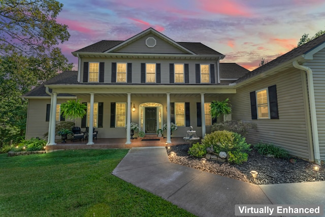 view of front of home with a porch and a lawn