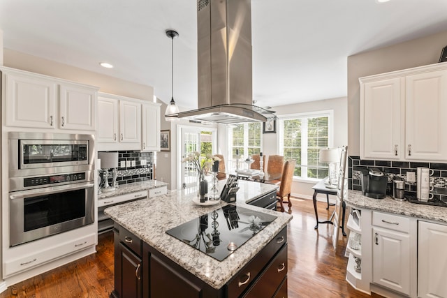 kitchen featuring island range hood, black electric cooktop, dark wood-type flooring, and white cabinetry