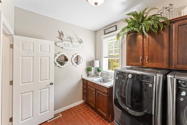 clothes washing area featuring cabinets, sink, and independent washer and dryer