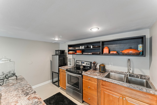 kitchen with sink, light stone counters, and stainless steel electric stove