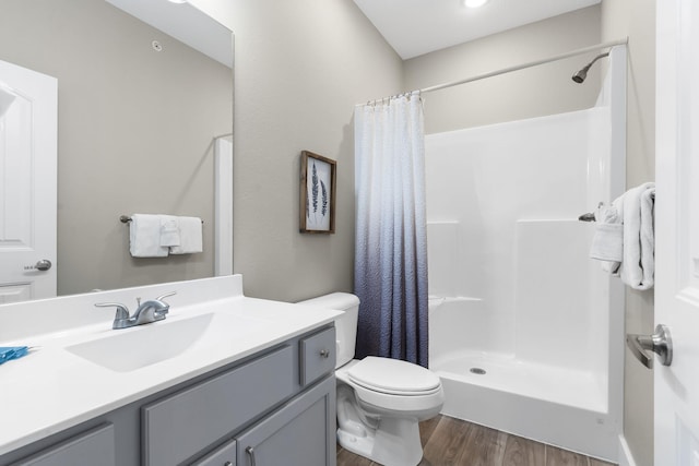 bathroom with wood-type flooring, toilet, vanity, and a shower with curtain