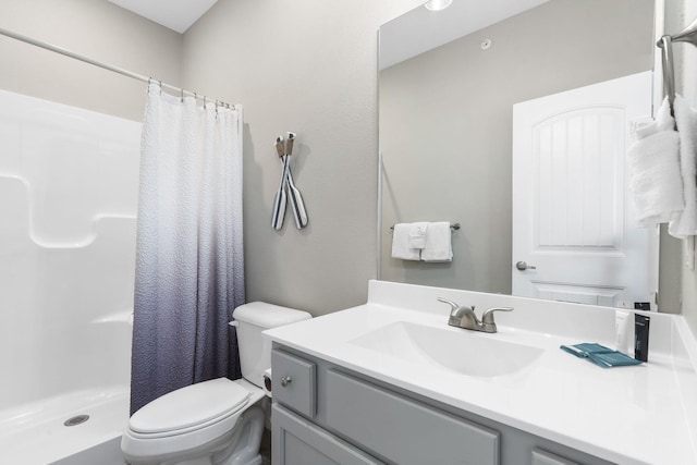 bathroom featuring vanity, toilet, and curtained shower