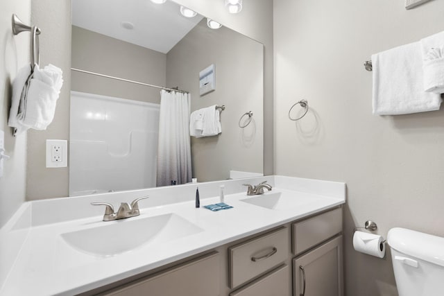 bathroom with walk in shower, vanity, and toilet