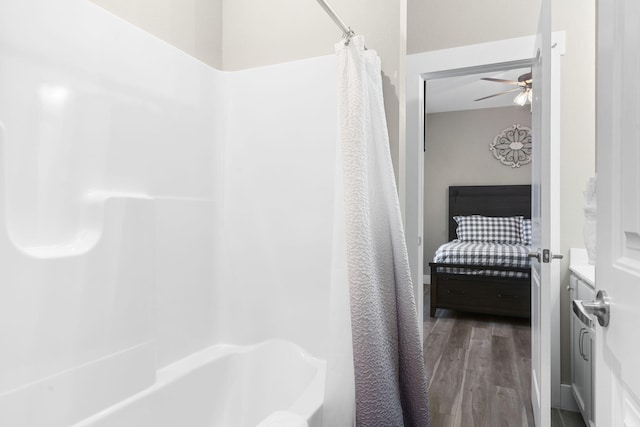 bathroom with wood-type flooring, vanity, shower / bathtub combination with curtain, and ceiling fan