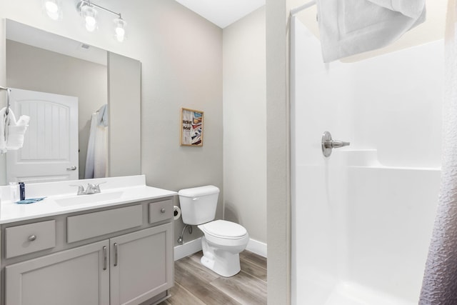 bathroom featuring curtained shower, hardwood / wood-style flooring, vanity, and toilet