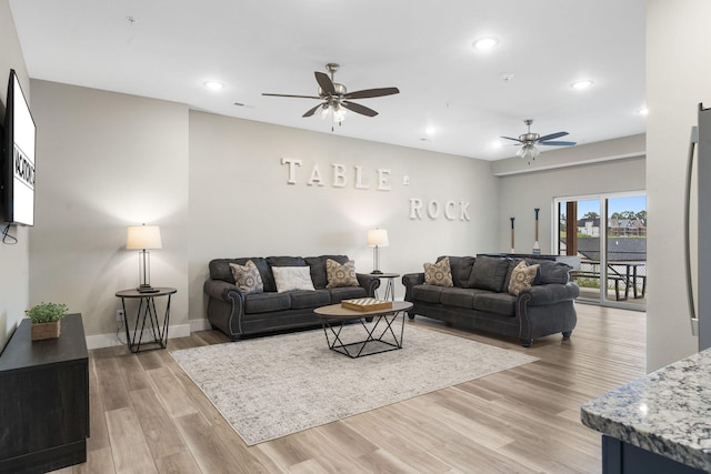 living room featuring ceiling fan and light wood-type flooring