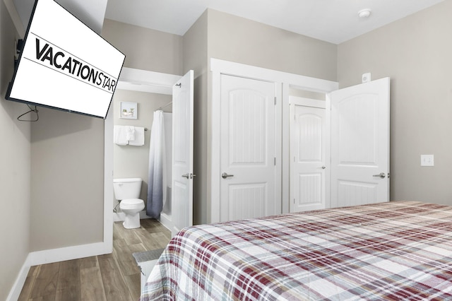 bedroom with a closet, hardwood / wood-style floors, and ensuite bath