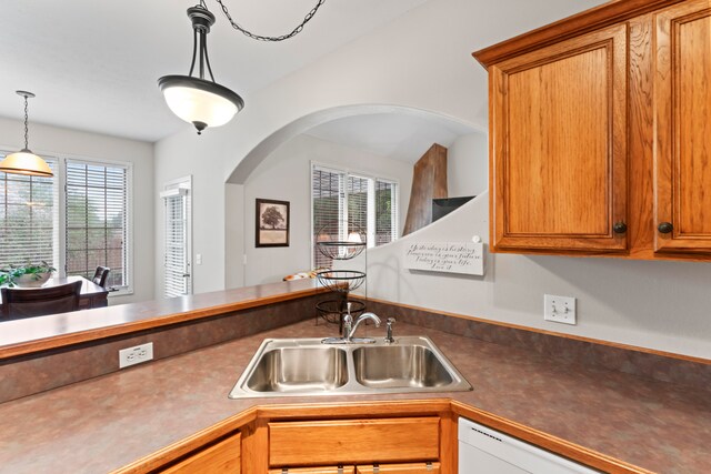 kitchen with a healthy amount of sunlight, hanging light fixtures, sink, and dishwasher