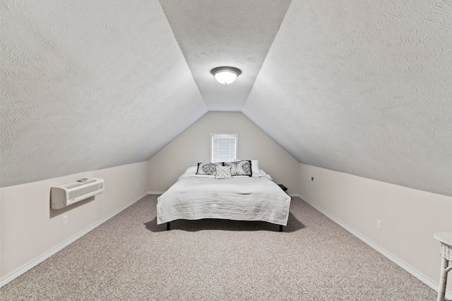 carpeted bedroom with a wall mounted air conditioner, vaulted ceiling, and a textured ceiling