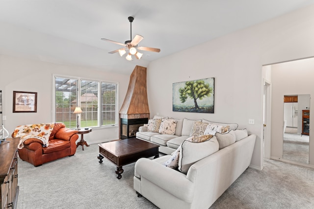 living room with a multi sided fireplace, light colored carpet, and ceiling fan